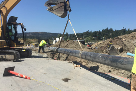Excavator lifting heavy pipe